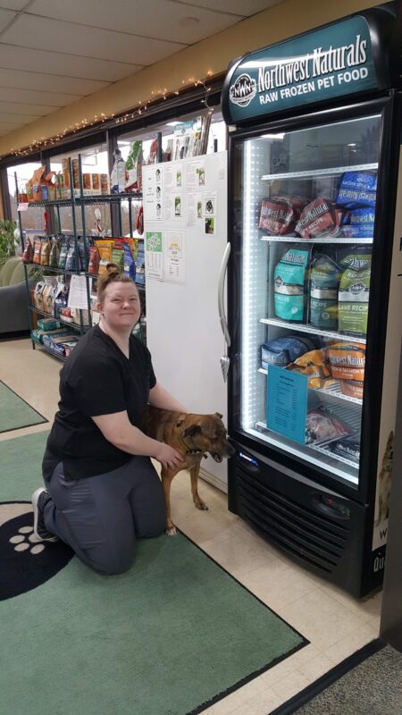 Alaura and her dog next to refrigerated northwest naturals products